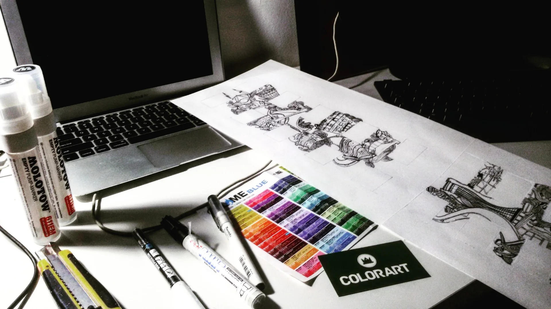Mesa de trabalho com desenhos e materiais do artista