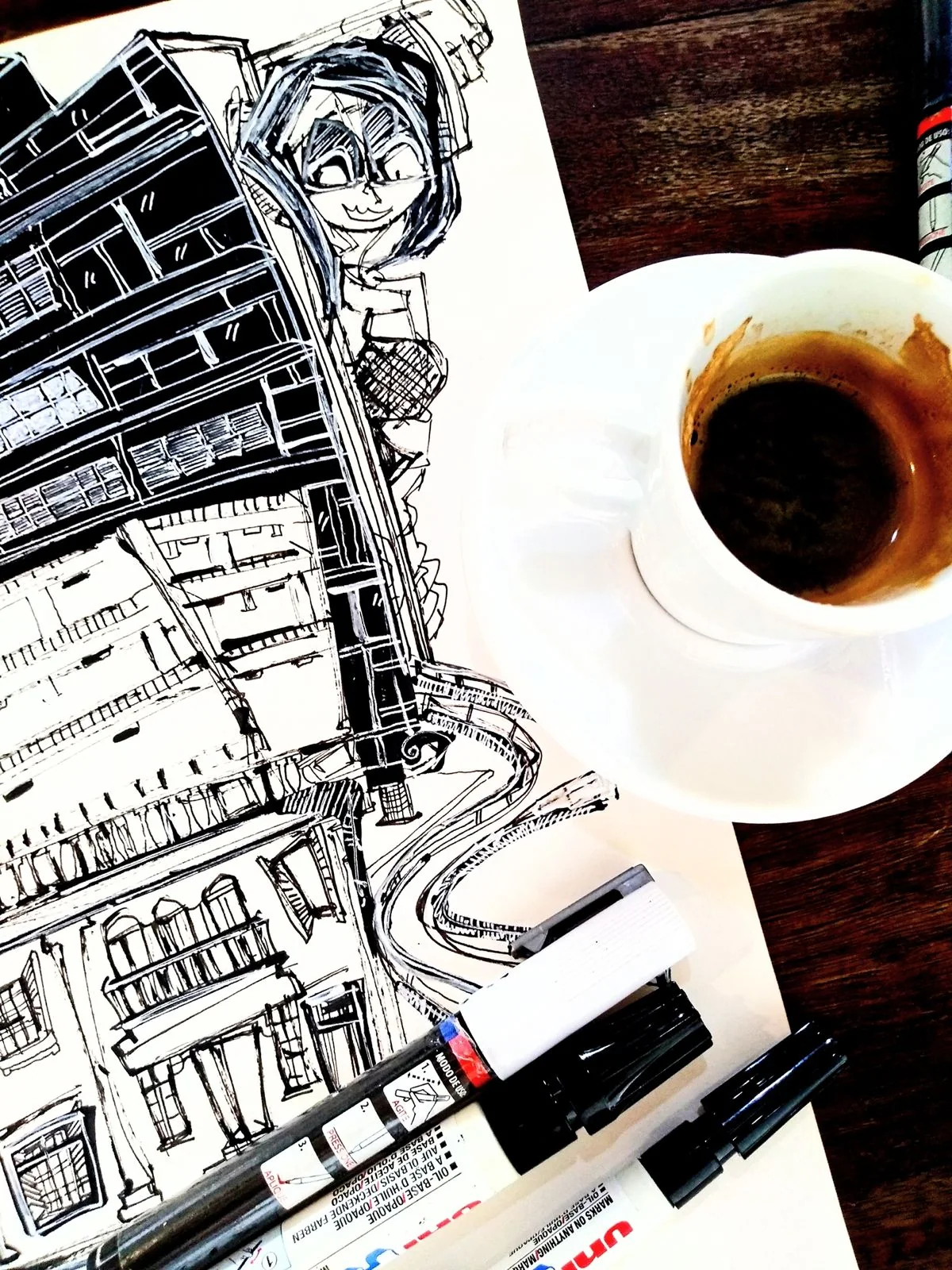 Desenho de arquitetura em processo ao lado de café e marcadores
